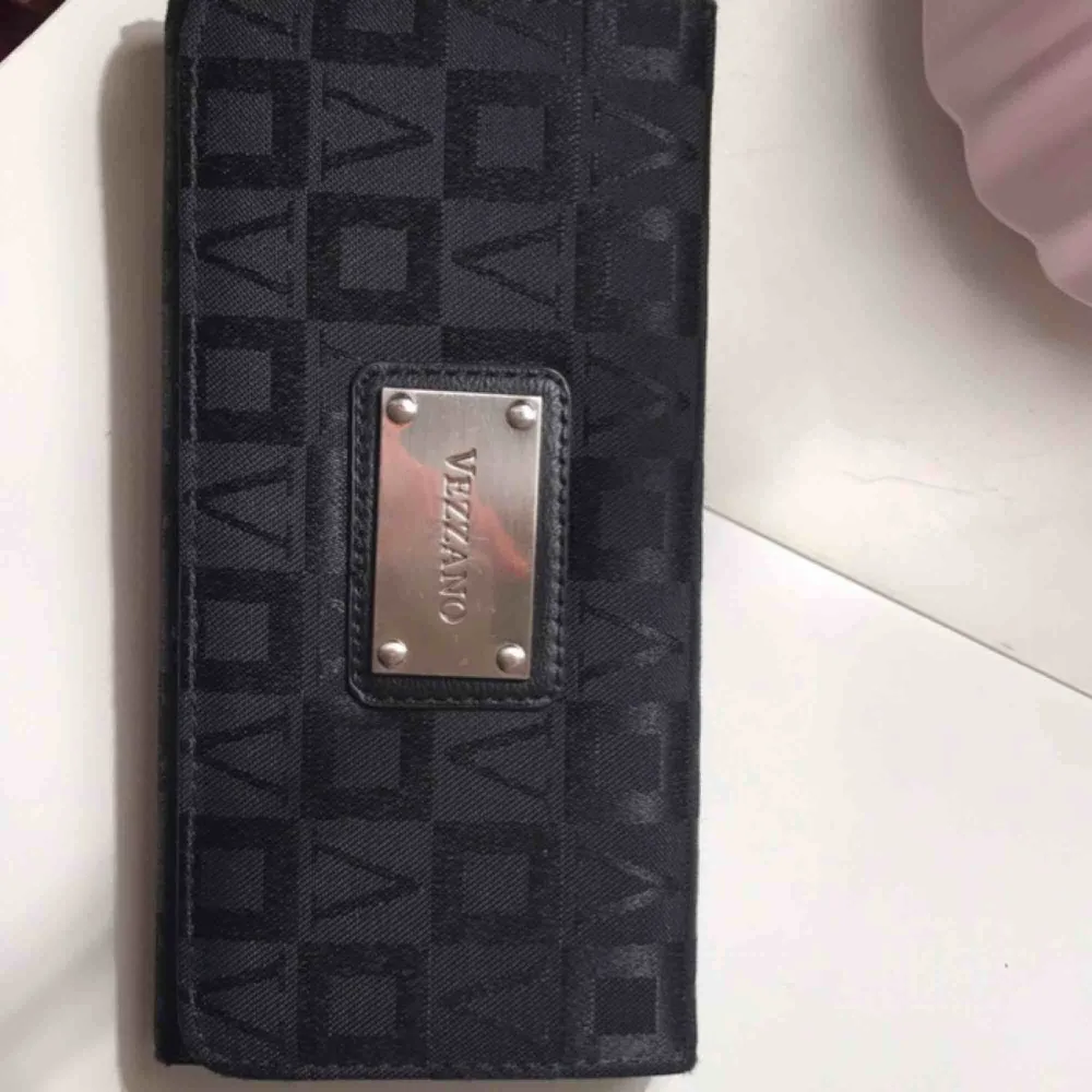 Jättefin plånbok av märket VEZZANO . Den är i bra skick och är jätte användbar Har plats för kort , sedlar , mynt och även mobil :) . Väskor.