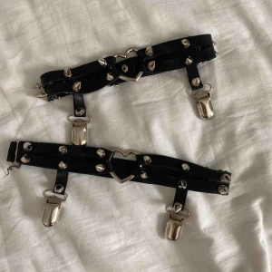  - Strumphållare med hjärta och nitar. Köpta för länge sedan men aldrig använda. Går att ställa in storlek på baksidan så borde passa de flesta. Vid frakt står köparen för fraktkostnaden.