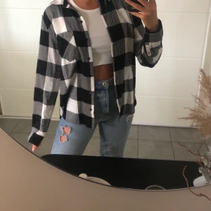 Rutig flanellskjorta - En svart/vit rutig flanellskjorta ifrån H&M divided  i strorlek 36. I ett bra skick, knappt använd. Köparen står för frakten:)