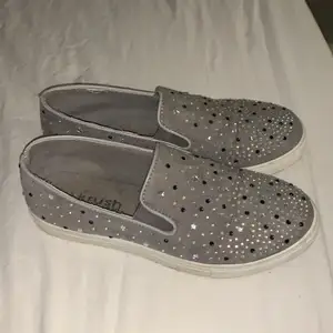 Snygga gråa skor med blåa och silvriga detaljer.
