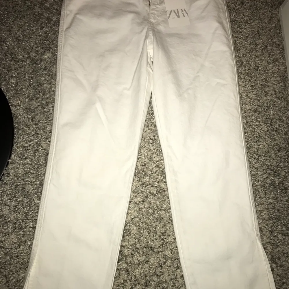 Säljer ett par helt oanvända, vita zara jeans med en slit längst ned på benet. Nypris 400. Möts upp vid köp💕. Jeans & Byxor.