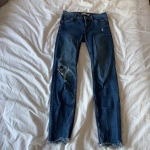 Skinny Jeans Från Bershka - Ett par skinny jeans från Bershka i blå tvätt med slitningar. Sitter riktigt bra men är tyvärr försmå för mig nu.  