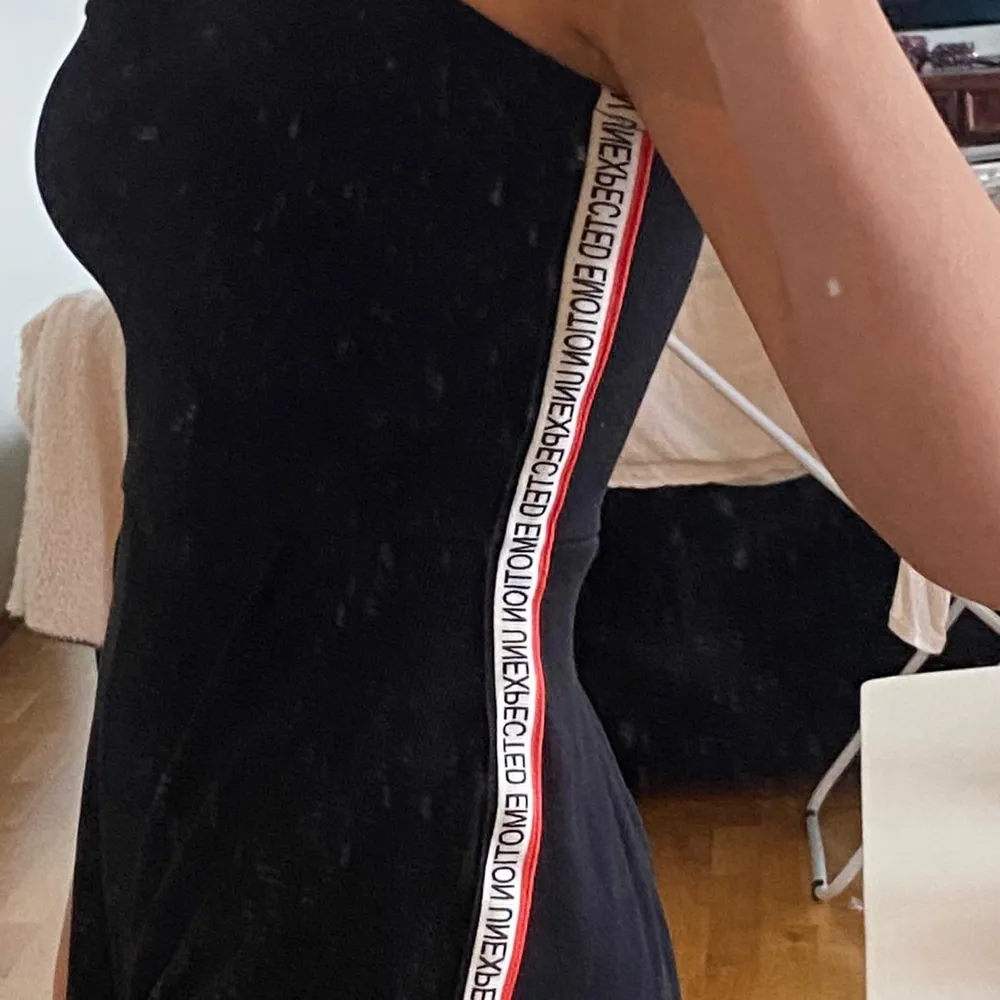En sjukt snygg svart jumpsuit med ett snyggt print på sidan där det står 