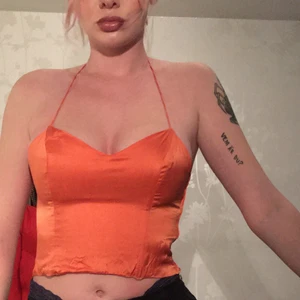 orange topp i silk - Köpt secondhand, säljer för att den blivit lite liten. Den har dragkedja på sidan och öppen rygg då snöret går runt nacken✨✨. (är lite skrynklig längst ner då den inte strykts eller något)💘