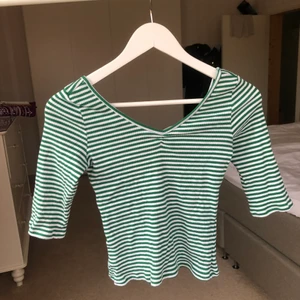 Grön randig topp  - Urgullig topp från Monki med knytdetalj bak i ryggen och trekvarts ärmar💖aldrig använd så i nyskick, storlek xs men är mer som en s och passar även en m då den är väldigt stretchig🥰