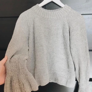  - Grå stickad tröja med volang i slutet av armarna. Storlek xs / passar även S.byter ej✨