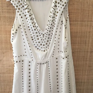  - Ursnygg! Köpt på köp&säljsajt men blev för stor. Säljaren säger att den är äkta och inköpt i Belgien. Vit bas med guldnitar. Skönt och svalt tyg! På några ställen har de blivit små små märken av nitarna men detta syns knappt. Köparen betalar frakt. 