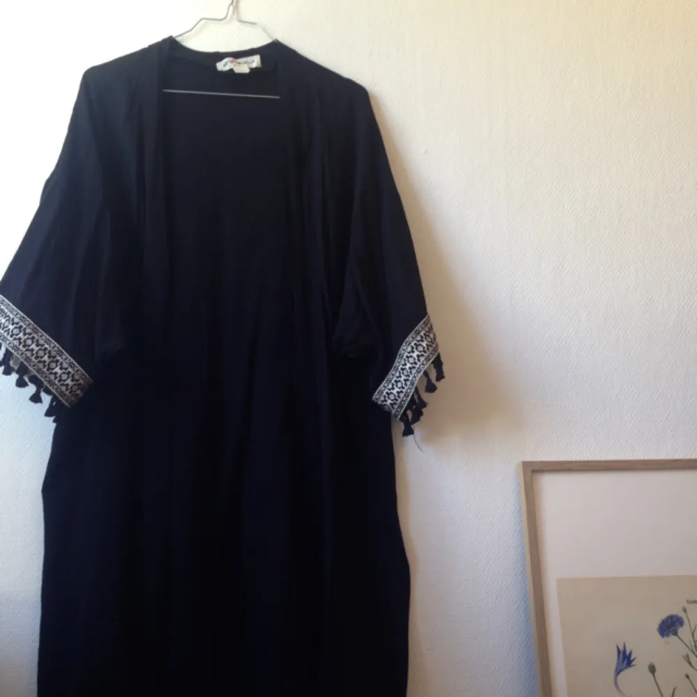 En svart kimono med vita detaljer. Vadlång. Tillhör Coachella-kollektionen från H&M. I mycket fint. . Tröjor & Koftor.
