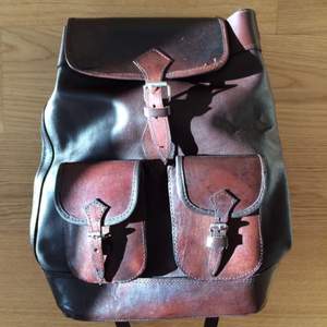 En ny unisex läder ryggsäck som köptes på en konstmarknad förra månaden i Bolivia. Använt en gång. Den rymmer en bärbar dator på 13tum. Väldigt snygg!