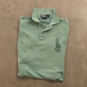 Ralph Lauren polo T-shirt  - En medium size Ralph Lauren polo, den passar med ett par ljuvliga shorts när man ska gå ut och golfa. Den är slim fit och är gjort av bomull. Har ett pyttelitet hål på ena armen men syns knappt och är fortfarande avändbar. DO NOT BLEACH IT.