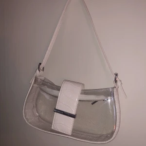 Vit transparent axelväska - Väska från asos som är slutsåld på hemsidan. Använd ca 3 gånger och är därför i bra skick. 