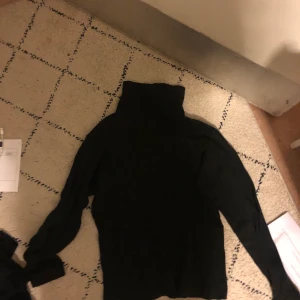 Svart polotröja  - En svart polotröja, lite tjockare material från U & F. 