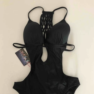  - Helt ny svart baddräkt med snygg ryggdetalj. Prislapp kvar på plagget. Hämtas i Malmö eller skickas mot frakt. 