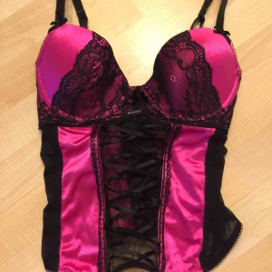  - FRI FRAKT Svart/Rosa korsett med spets från New Yorker. Snörning i fram, BH spännen i bak