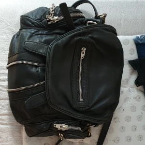  - Selling my original Alexander Wang "Marti" backpack, I've had it for a couple of years, still in wonderful condition with minimal signs of use. I still have the dustbag and the original box in which it came, if needed, as well as the receipt. It comes with backpack straps as well as a single shoulder strap. I've loved it and used it, but since I'm  going all vegan I'm not interested in owning leather goods. 