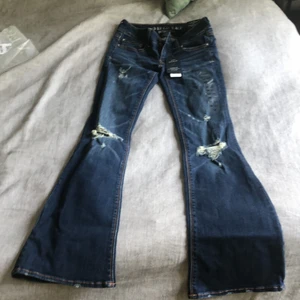 American Eagle jeans - Mörkblåa slitna American Eagle jeans Flare och super stretch,  aldrig använda med lappen kvar!  