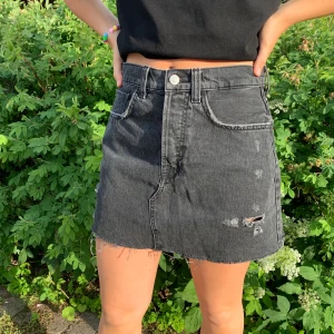 Jeanskjol med slitningar - Superfin jeanskjol med slitningar!! Knappt använd då den tyvärr är lite stor för mig