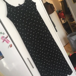 Långklänning stl 38 - Svart klänning med vita prickar. Två slits fram. Knappar fram. Spagetti straps. 