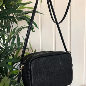 Axelremsväska  - Svart Axelremsväska från H&M med ställbar längd. Använt skick men absolut inget fel på den. Säljer för 70kr och köparen står för frakten (: