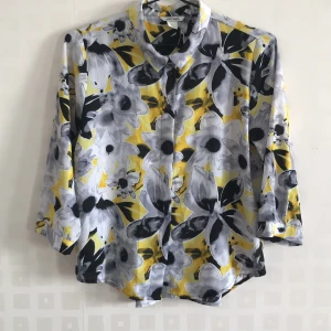 Blus i retrostil - Den här blusen har varit en favorit i garderoben, då den passar till alla tillfällen. Den har ett fint fall i ryggen och ett härligt blommigt mönster. Köparen står för frakten.