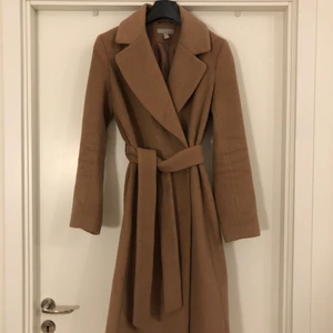 Ullkappa från HM  - Trendig ullkappa från HM. Använd 2 säsonger men hel och bra skick. 50% ull, färg camel. Nypris 1450kr 
