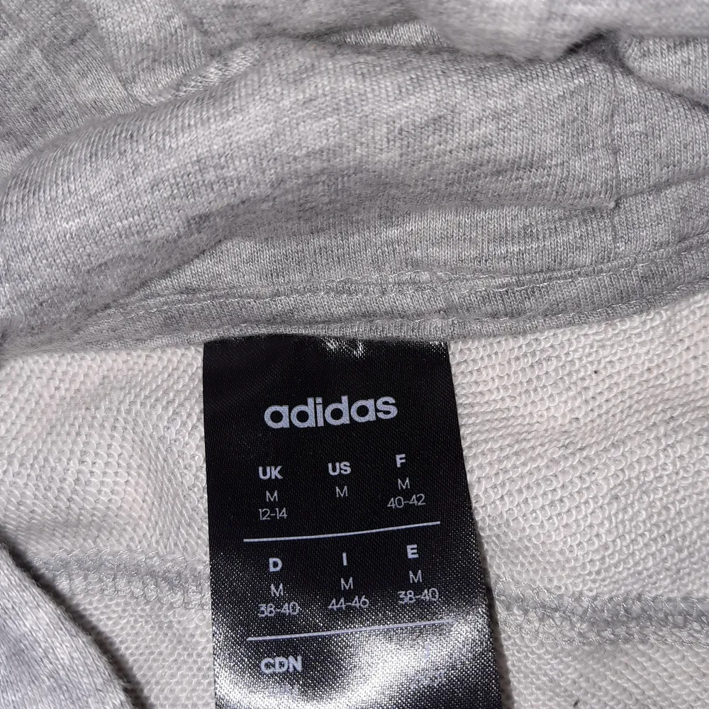 Grå adidas hoddie i storlek M. Använd ett få tal gånger men mycket bra skick. . Hoodies.