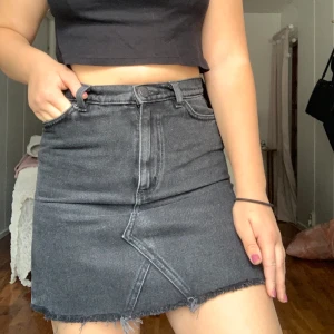 kjol från Monki, strl 34  - Fin jeanskjol från Monki i grå/svart färg, har slitningar/fransar nertill. Fickor fram och bak. Knappt använd men är tyvärr något liten för mig. Köparen står för frakten. 