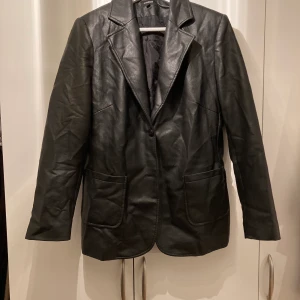 Fakeläder kavaj strl 40 - Nästan oanvänd fakeläder kavaj.  Finns i Sthlm. Kan mötas upp alt skicka! Mottagaren betalar frakt. 