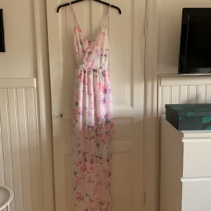 Långklänning med slits - Jättefin Blommig långklänning fr ginatricot, med slits på sidorna och underkjol. Använd en gång