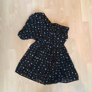  - Enarmad klänning med tunt tyg och undertyg.  Storlek M - men är kort och känns som en XS/S. Vita stjärnor 