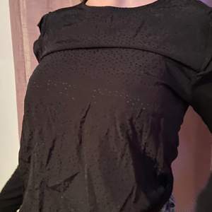 En svart tröja med svagt prickigt mönster på framsidan och en plan baksida. Använd ett få tal gånger. Storlek 170. märke: PompDeLux, pris 90kr + frakt