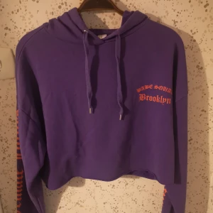 Croppad hoodie✨ - En lila croppad hoodie med tryck, främst på ryggen. Det står female future på ärmarna, och babe squad på ryggen.🌼