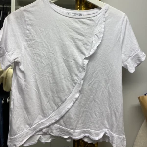 Topp med volang  - Vit topp / T-shirt med volang från Mango. Frakt tillkommer.