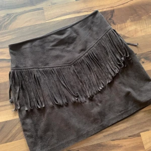 Hollister mockakjol - Mörkbrun kjol i mocka från Hollister, aldrig kommit till användning. Dagkjedja och hyska på sidan, stretchig. Mockatyg även på insidan så mycket bekväm. Bilder på hur den sitter på kan skickas privat. 🌸