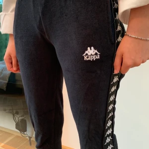Kappa trackpants - Kappa trackpants i velour, har ”poppers” på sidan så man kan knäppa upp byxorna hela vägen💕 Är i strl XS och är ganska små i storleken så passar de som är ungefär ~160cm😊