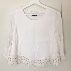 Crop top blus - Vit top med mönster nertill.