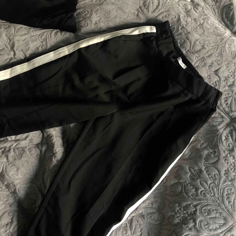 Coola svarta kostymbyxor med vit rand på sidorna! Använd max en gång och är i nyskick som när den var köpt!🥶  (Priset kan diskuteras);). Jeans & Byxor.