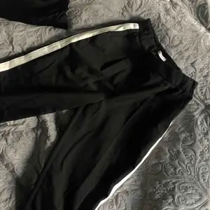Coola svarta kostymbyxor med vit rand på sidorna! Använd max en gång och är i nyskick som när den var köpt!🥶  (Priset kan diskuteras);)
