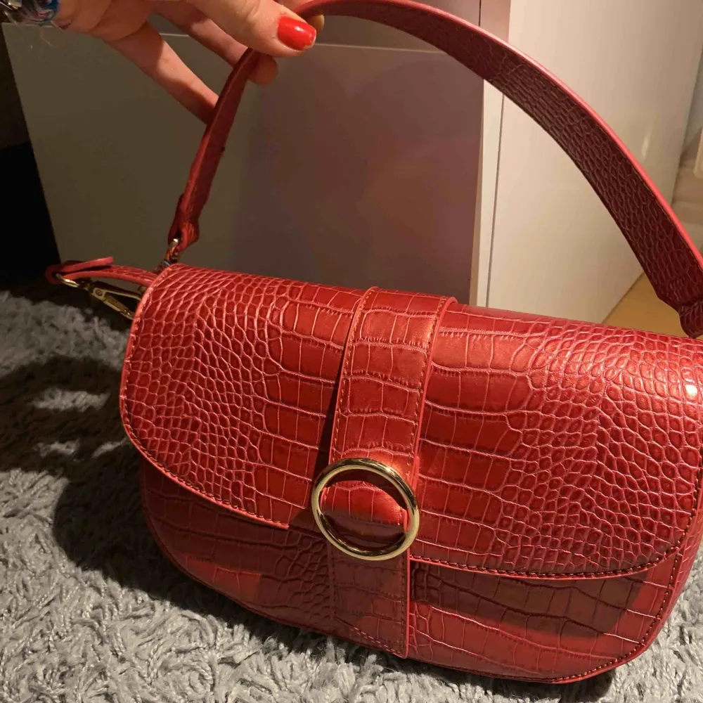 En väldigt fin och rymlig röd väska från NAKD som jag köpte för ett tag sen men har inte fått anständig av den tyvärr! Den är i helt nytt skick. Det tillkommer ett långt och ett kort axelband! Priset är inräknad med frakt:). Väskor.