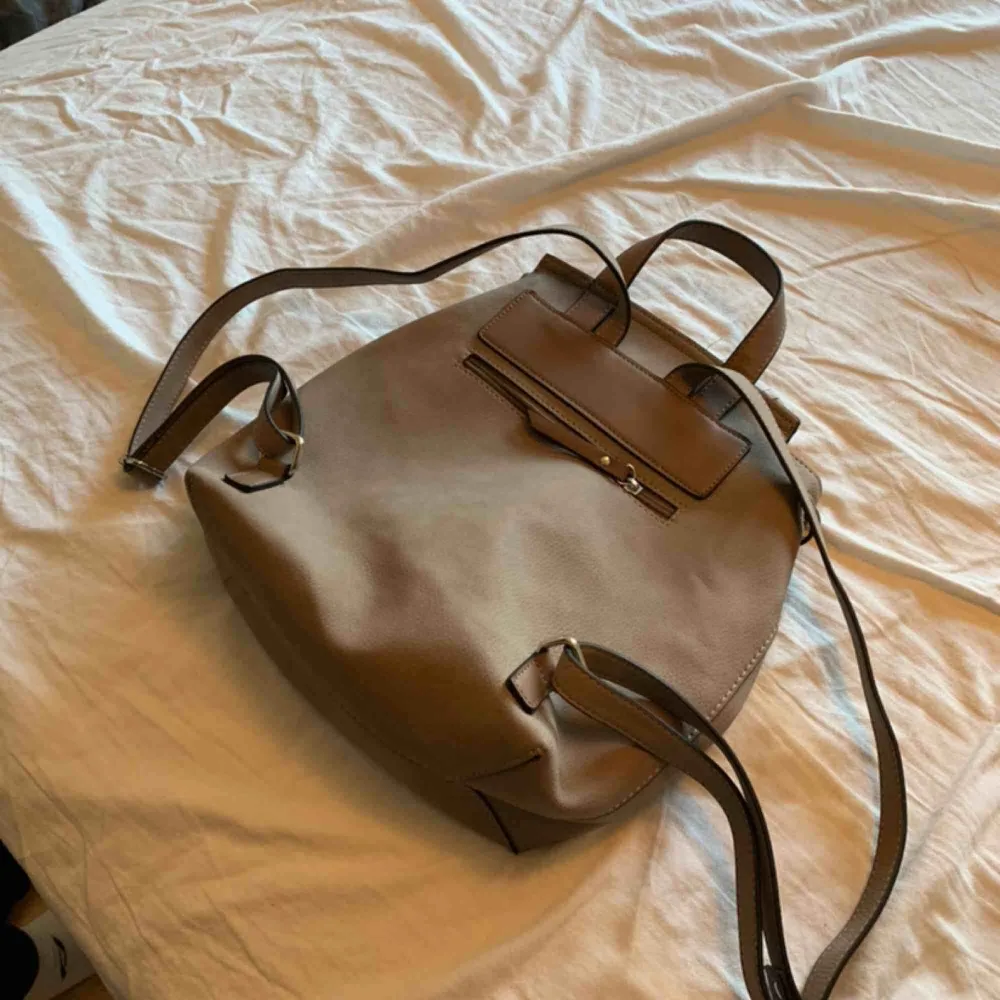 En ryggsäck från Åhléns. Den är beige och aldrig använd  . Accessoarer.