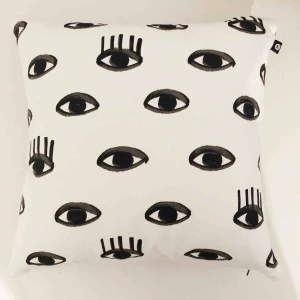  - Ett kuddfodral i storlek 45x45cm från Lagerhaus. Det är vitt med svarta ögon på.