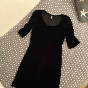  - Sammet klänning med korta puff armar.  Sitter tajt på kroppen. 