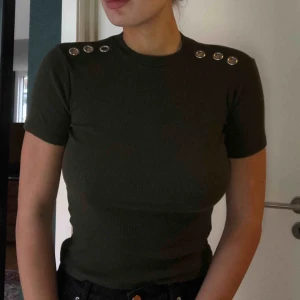  - Militärgrön tröja med coola detaljer på axlarna. 