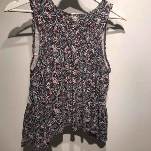  - Ett fint linne köpt på kreta inne på affären Jennyfer, tyvärr för litet. Öppet i ryggen med små rosetter! Bra skick och är supersnyggt till ett par mörkblå shorts på sommaren!