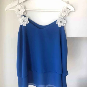  - Super sött linne med blom detaljer vid axelbanden. Lös passform, därför passar den både xs,s och m. Aldrig använd! 