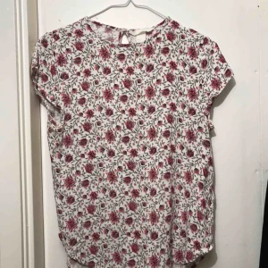  - Söt topp med rosa blommor. Perfekt till sommaren! Använd men med mycket kvar att ge. Frakt inom Sverige ingår. 