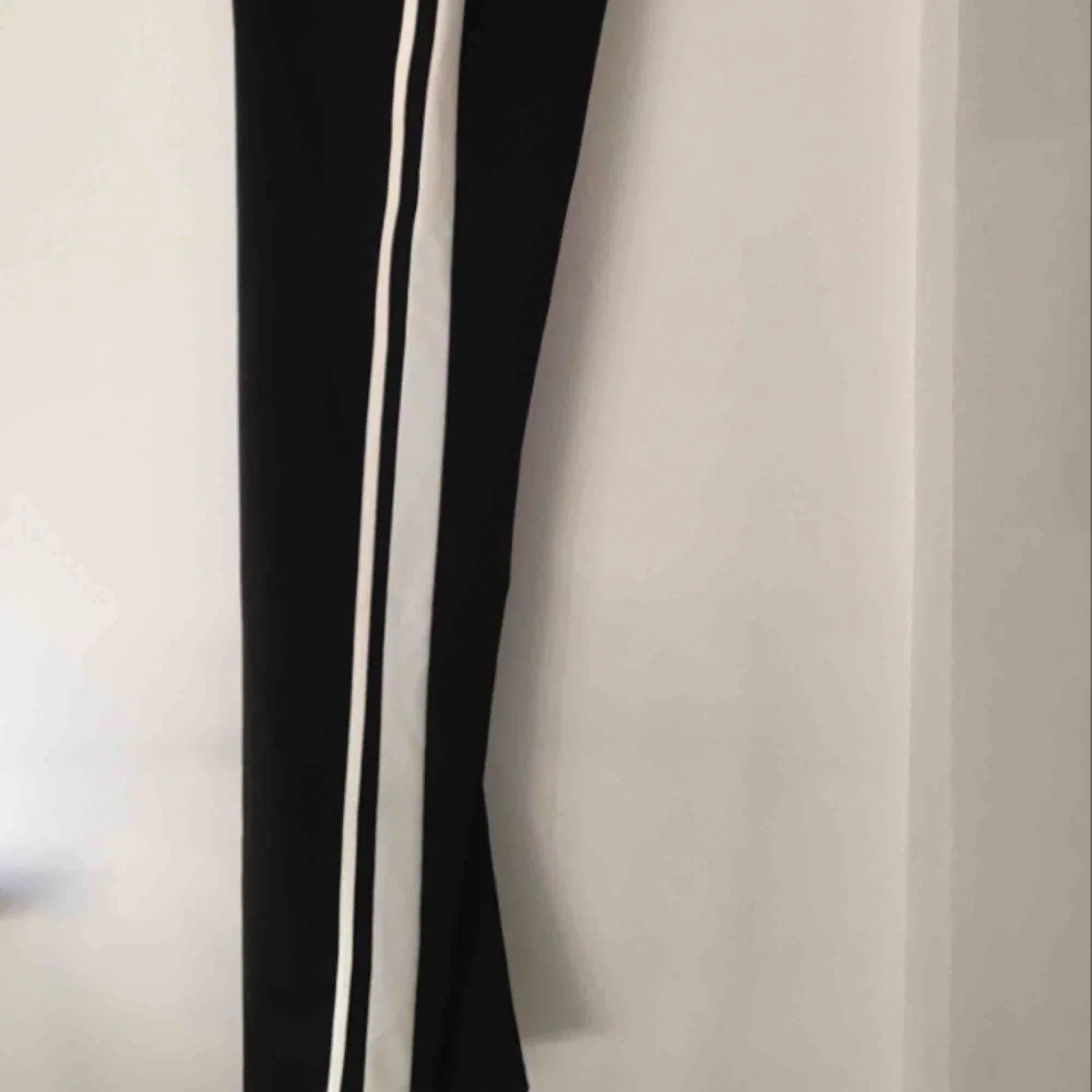 Trackpants från ginatricot svarta med två vita räder. Jeans & Byxor.