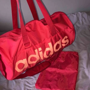  - Ganska liten och smidig träningsväska från adidas. Väskan har innerfack och fack utanpå med dragkedja på vardera sida. Matchande skopåse medföljer. Har knappt använt den så den är i nyskick. 