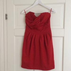 Röd axelbandslös klänning från H&M. Strl 36 aldrig använd. Skönt och elastiskt material. 
