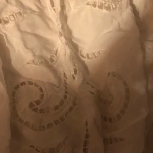 Vit blus  - Vit blus med blomdesign från H&M. Hund och katt finns i hemmet. 